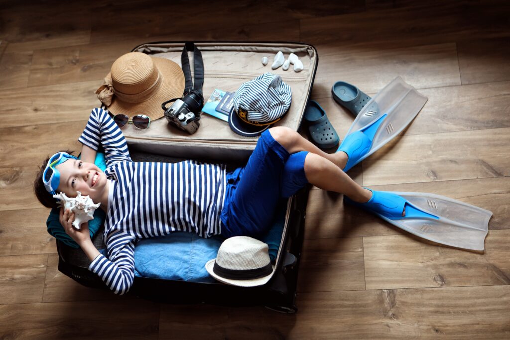 Boy And Suitcase .Suitcase Folded On Vacation. Planned Trip To The Sea.flat Lay Travel