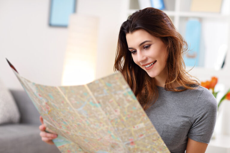 Happy woman with map at home planning holidays